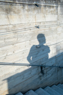 Urban architecture concrete wall and stairs in sunlight casting shadow as abstract silhouette with strong perspective and depth lines