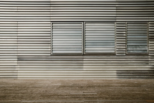 Modern architecture facade with metal louvers and window pattern showing texture on minimal industrial wall for urban exterior design