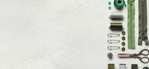 Different tailor's supplies with measuring tape on white grunge background with space for text