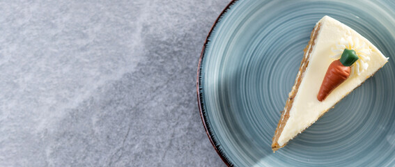 Carrot cake slice with cream cheese frosting on gray stone. Panorama view. Copy space
