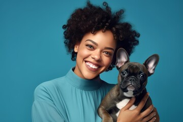 Obraz premium Smiling woman holding a brown french bulldog puppy, expressing joy and companionship