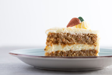 Carrot cake slice with cream cheese frosting on white background