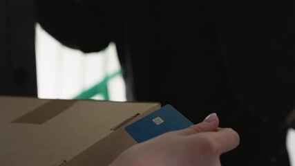 hands exchanging package payment card doorstep closeup sequence shows courier scanning card for contactless delivery, customer hand reaching for parcel, urban entryway, muted lighting, secure