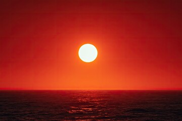 Large, bright sun setting over calm ocean, painting sky vibrant reds and oranges