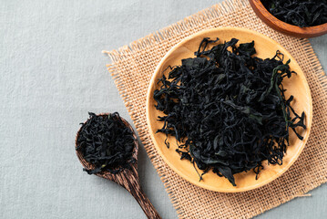 Top view of dried wakame seaweed on a wooden plate and spoon, Healthy Asian food ingredient
