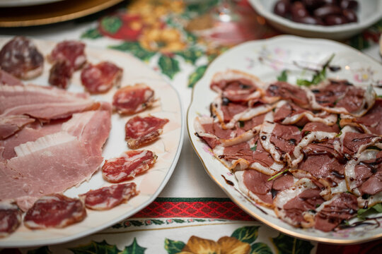 grandi piatti con vari antipasti a base di fette di salame e prosciutto cotto da un lato e fette di petto d'anatra ed aceto balsamico dall'altro