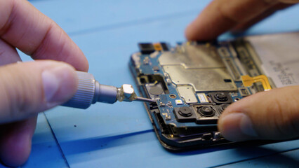 Close up of hands repairing a broken smartphone screen