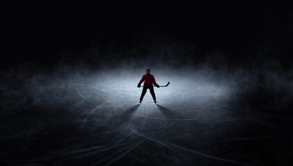 Obraz premium Dramatic artwork ice hockey player standing alone on dark rink. Concept of mental focus before game, professional sport pressure, readiness for competition, dramatic ice background.