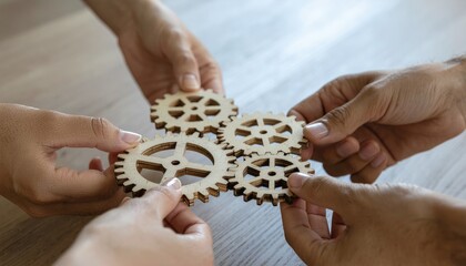  A dynamic image showing diverse hands connecting wooden gears, symbolizing teamwork and innovation in business