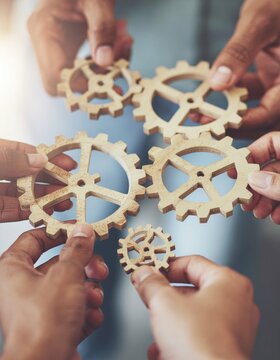  A dynamic image showing diverse hands connecting wooden gears, symbolizing teamwork and innovation in business