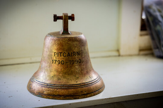 Adamstown, Pitcairn Islands - 02 January 2026: View of a weathered bronze bell, its tarnished surface whispering tales of the island's past, resting on a sunlit windowsill.