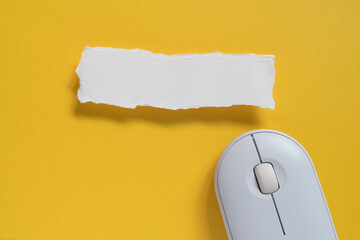 uneven torn blank white paper with path of wireless computer mouse on grunge yellow paper, top view