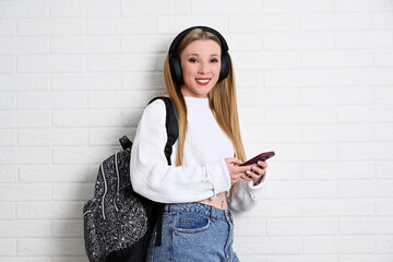 Portrait of female student with backpack and smartphone