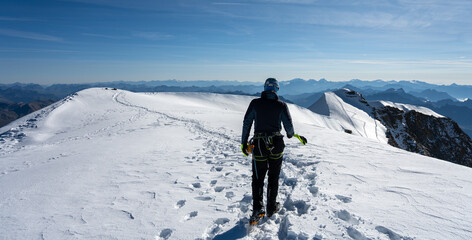 A climber makes their way to the summit of Piz Palu, surrounded by stunning glaciers and majestic...
