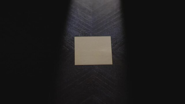 "Shit" written on a Sticky Note with a sharpie and placed on a table under dramatic lighting