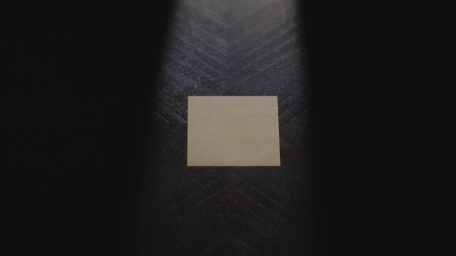 "Ideas?" written on a Sticky Note with a sharpie and placed on a table under dramatic lighting