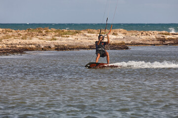 Mature man practicing kitesurfing. Aquatic sport. Athletic healthy senior