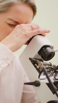 Glasses, woman optometrist or microscope in office, identify lens features or optical center location. Verify prescription, specs or mature optician with lensmeter for quality check, examine or test