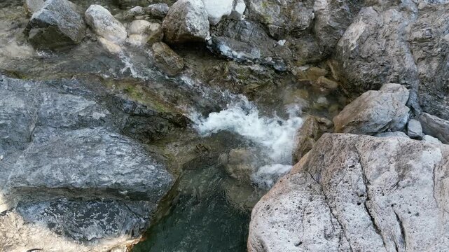 Aerial drone footage over the Susaibes stream near Andreis, Italy: clear water, rocky bed and pristine alpine surroundings. Ideal for nature, travel and scenic stock footage.