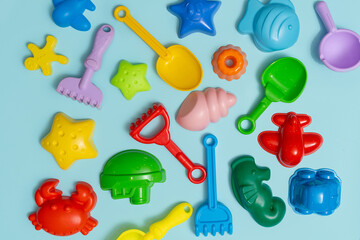 Children's sandbox toys on a blue isolated background, a place for text, flat lay
