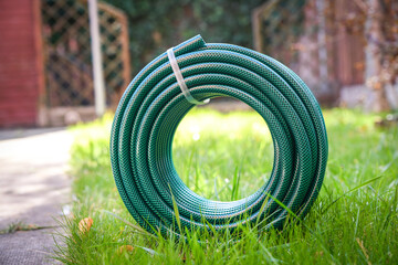 A newly purchased garden hose, still neatly coiled and unused, 