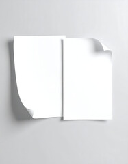 Two white paper sheets on a gray surface. One sheet has a curled corner