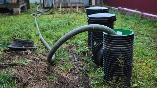 Sewage pumping service clearing a septic tank system in a rural backyard
