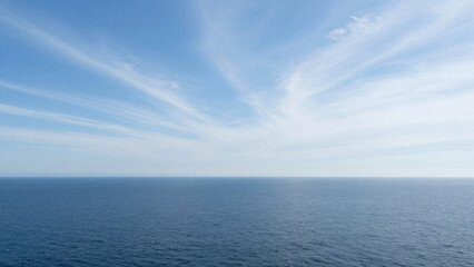 Obraz premium A peaceful and expansive view of the open ocean meeting the bright blue sky at the horizon, creating a serene and endless natural landscape