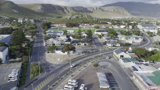 Drone flies north over city and over Hoy's Koppie in the late afternoon along the Garden Route on a sunny day in Hermanus, South Africa