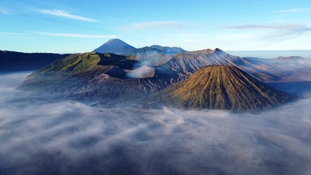 A bird's-eye view of the eruption of Bromo volcano at dawn in Bromo-Tengger-Semeru National Park, East Java, Indonesia. The caldera of Tengger volcano is hidden by clouds and fog. Dron.4K