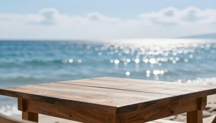 Empty wooden table on a sandy beach with the sparkling ocean in the background