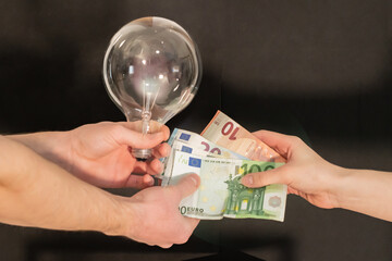 Cash exchange for electricity. People exchange euro banknotes for a light bulb or energy resources. Energy costs and rising costs. Rising resource prices.