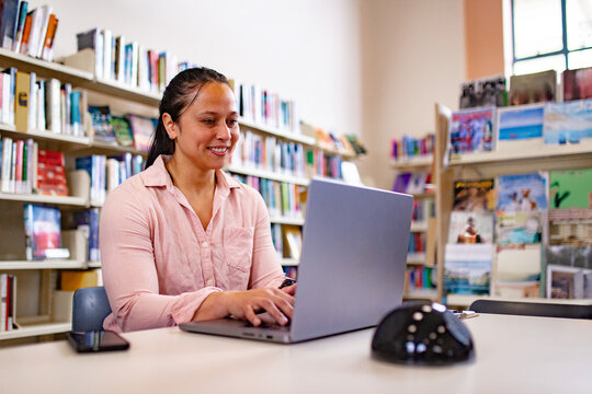 Maori woman studying and working with a laptop at a public library