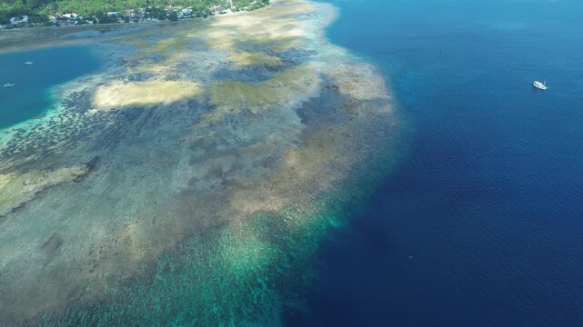 Aerial upward spiral movement over bright patch reefs in clear blue sea, Banda Sea, Maluku, Indonesia