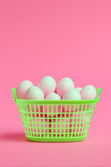 neon green basket filled with glowing pastel eggs centered against a solid blush pink background.