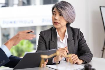 Lawyer, solicitor or barrister, supervisor talk to analyse case report, discussing paper policy terms conditions with client, conduct lawsuits document