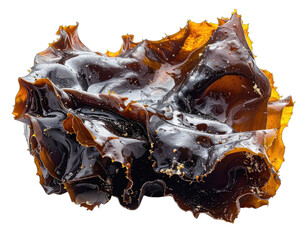 Close-up of amber and dark brown cannabis concentrate against a black background.