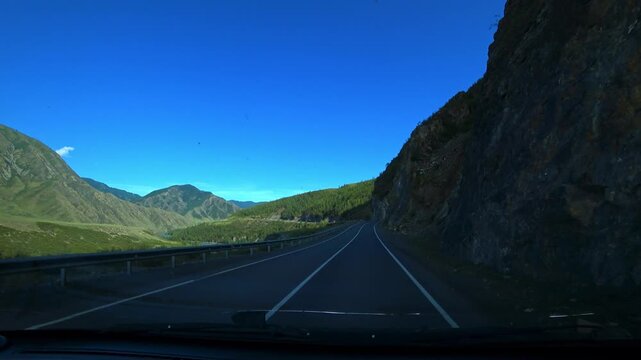 Altai, June 9, 2022: The Chuy Highway is one of the most picturesque roads in the world. A view of the Altai Mountains from a car window. Plains, mountain ranges, and narrow valleys. 4К