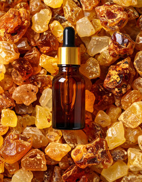 Mirra &oacute;leo essencial, Amber glass bottle with pipette gold on top of Commiphora myrrha Guggulu, Commiphora  essential oil, photo seen from above, aromatherapy