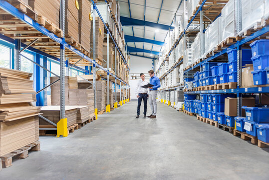 Warehouse business meeting with clipboard in industrial production hall