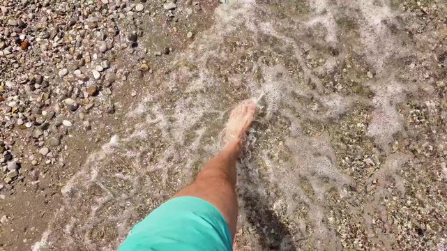 Man sunbathing on a rocky sea ocean beach.