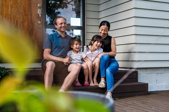 Mixed ethnicity family seated on the porch deck