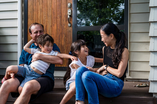 Mixed ethnicity family seated on the porch deck