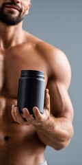 Naklejka premium Fit young caucasian male holding black protein jar in athletic pose