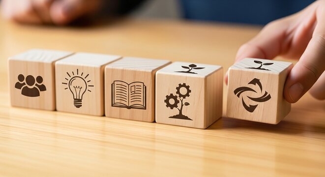 Wooden blocks with icons showing teamwork idea learning growth and sustainability arranged on a table