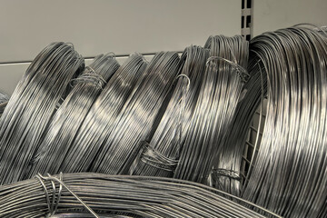 Shiny coils of metal wire stacked neatly in a hardware store aisle
