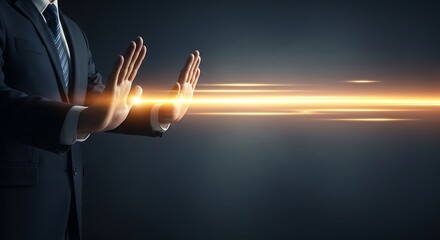 Businessman in dark suit holding up hands to stop a strong horizontal beam of bright golden light representing energy or data flow in abstract darkness