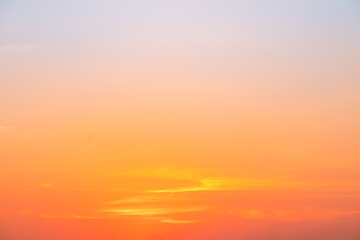 Obraz premium Sunset or sunrise sky with a vibrant gradient of orange, gold, and soft blue. Clear atmosphere with wispy clouds. Peaceful, natural light background. hope, freedom, new day and inspirational Concepts