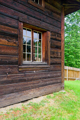 Corner of the building with window made of dark wooden beam