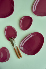 Empty plates with a modern design are oval asymmetrical and with a rich dark purple color and...